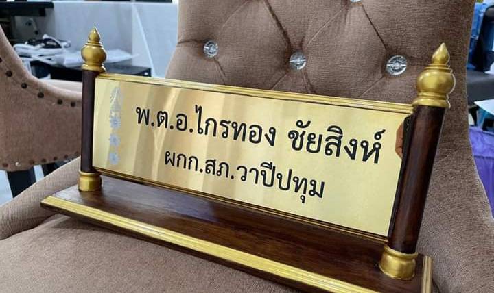 ป้ายชื่อตั้งโต๊ะไม้สัก ติดแผ่นสแตนเลสทองกัดกรด ตกแต่งด้วยหัวบัวทำสีทอง ขนาดแผ่นทอง 11x36ซม.