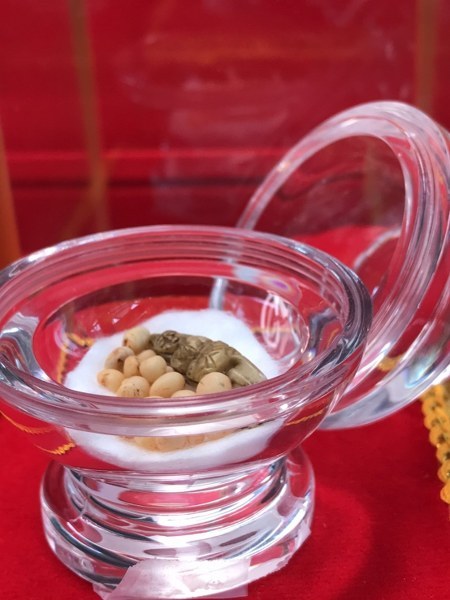 พระทันตธาตุหลวงปู่ครูบาชัยยะวงศา แกะเป็นรูปพระพุทธรูป พร้อมกับพระธาตุข้าวบิณฑ์