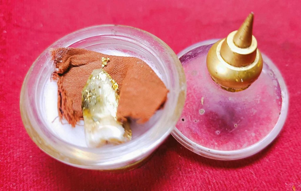 พระทันตธาตุ ครูบาธรรมธิ วัดสันป่าตึง อ.แม่แตง จ.เชียงใหม่ ได้มาจากพ่อหนานจักร อายุ 82 ปี ปัจจุบัน (พ.ศ.2567) ยังมีชีวิตอยู่ แม่แตง จ.เชียงใหม่ เคยบวชรับใช้ครูบาธรรมธิ ตั้งแต่ปี 2529 - 2536 และสึกในปี 2540 ท่านได้พระทันตธาตุนี้มาเมื่อปี 2536