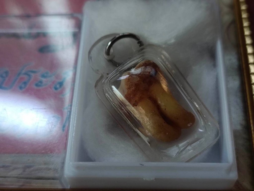 พระทันตธาตุ และรูปถ่ายบูชา ครูบาคำปัน ปภากโร (พระครูรัตนประภากร) วัดนาแส่ง ต.นาแส่ง อ.เกาะคา จ.ลำปาง เจ้าของชื่อ ลุงมูล อายุ 78 ปี ทำอาชีพขายของชำใน อ.ในเมือง จ.ลำปาง คุณลุงมูลเก็บวัตถุมงคลของครูบาคำปันไว้เยอะ โดยพระทันตธาตุนี้ได้มาเมื่อปี 2548