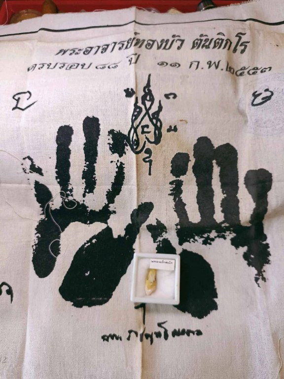 พระทันตธาตุ ผ้ายันต์ หลวงปู่ทองบัว ตันติกโร วัดโรงธรรมสามัคคี อ.สันกำแพง จ.เชียงใหม่ ได้มาจากคุณจรินทร์ อดีตเป็นผู้ช้วยผู้ใหญ่บ้านใน อ.สันกำแพง ปัจจุบันอายุ 68 ปี (บันทึก พ.ศ.2566) ท่านเป็นลูกศิษย์หลวงปู่ทองบัว ได้พระทันตธาตุองค์นี้มาเมื่อปี 2550