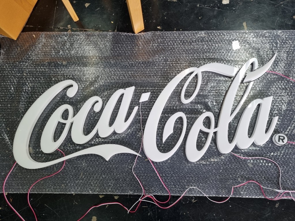 อักษรไฟออกรอบตัว ''โคคา โคล่า''